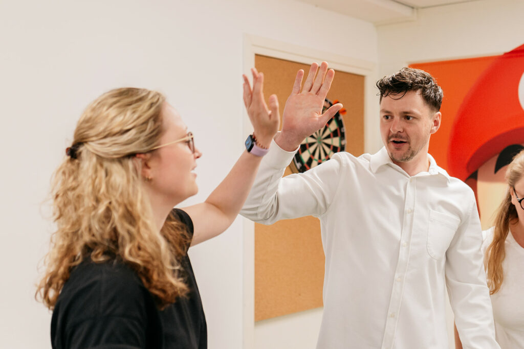 Op de foto geven twee collega's van Warmgarant elkaar een high-five